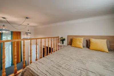 a bedroom with a large bed with yellow pillows at ALPARI apartments in Kraków