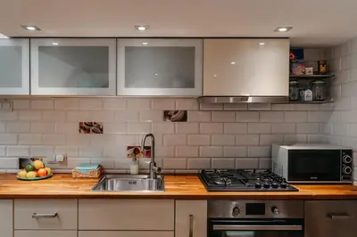 a kitchen with a sink and a microwave at ALPARI apartments in Kraków