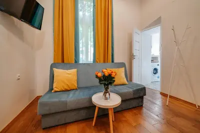 a living room with a couch and a table at ALPARI apartments in Kraków