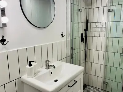 a white bathroom with a sink and a mirror at Cozy Studio with mezzanine - Old Town, Kazimierz in Kraków