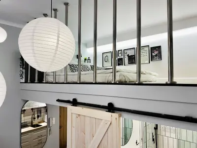 a bedroom with a large mirror above a bed at Cozy Studio with mezzanine - Old Town, Kazimierz in Kraków