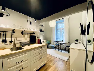 a kitchen with white cabinets and a black ceiling at Cozy Studio with mezzanine - Old Town, Kazimierz in Kraków