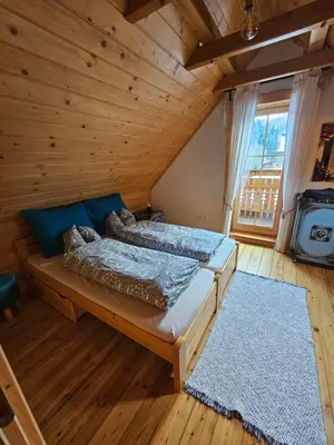 a bedroom with two beds in a log cabin at Osada Mała Kozówka in Myślenice