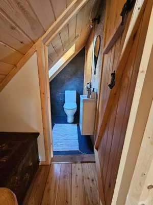 a bathroom with a toilet in a wooden house at Osada Mała Kozówka in Myślenice