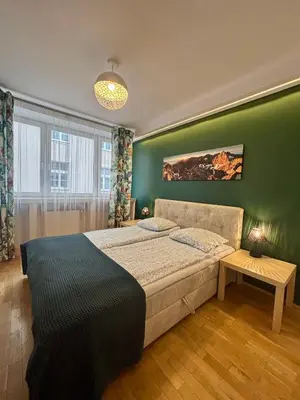a bedroom with a bed and a green wall at Vintage Tomasza 25 Apartments in Kraków