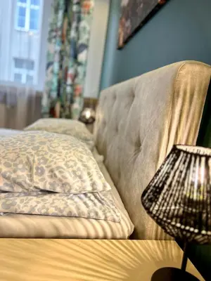a couch with a pillow and a end table at Vintage Tomasza 25 Apartments in Kraków