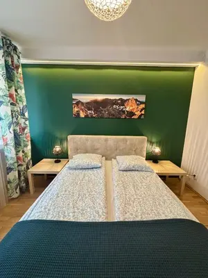 a bedroom with two beds and a green wall at Vintage Tomasza 25 Apartments in Kraków