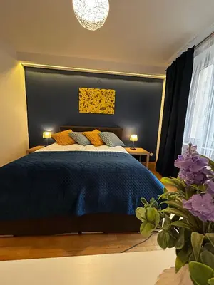 a bedroom with a blue bed with yellow pillows at Vintage Tomasza 25 Apartments in Kraków