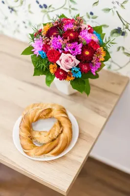 a table with a bowl of flowers and a pretzel at Vintage Tomasza 25 Apartments in Kraków