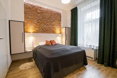 a bedroom with a bed and a brick wall at Green - Apartamenty Kleparskie in Kraków
