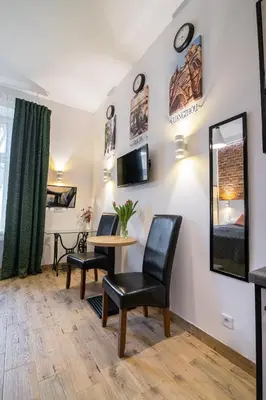 a room with a table and chairs and a bed at Green - Apartamenty Kleparskie in Kraków
