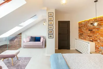 a bedroom with a brick wall and a couch at St Thomas Residence Old Town in Kraków