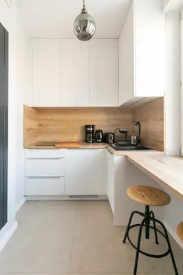 a kitchen with white cabinets and a stool at St Thomas Residence Old Town in Kraków