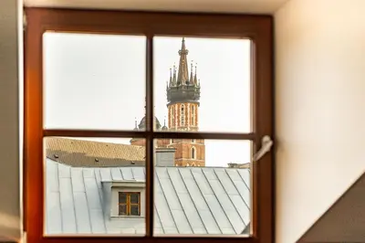 a view of a clock tower through a window at St Thomas Residence Old Town in Kraków