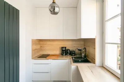 a kitchen with white cabinets and a sink at St Thomas Residence Old Town in Kraków