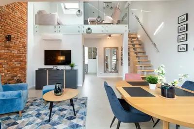 a living room with a table and chairs and a staircase at St Thomas Residence Old Town in Kraków