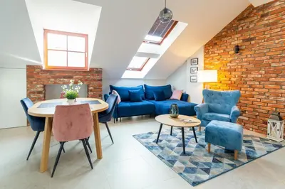 a living room with a blue couch and a brick wall at St Thomas Residence Old Town in Kraków