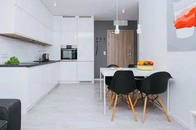 a kitchen with a table and black chairs at Horizon Apartments - Krowoderska in Kraków
