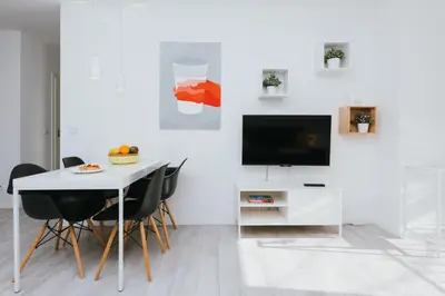 a dining room with a white table and a television at Horizon Apartments - Krowoderska in Kraków