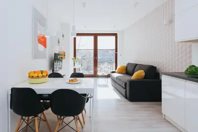 a kitchen and living room with a table and chairs at Horizon Apartments - Krowoderska in Kraków