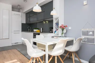 a kitchen and dining room with a white table and chairs at Horizon Apartments - Krowoderska in Kraków