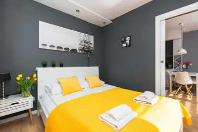 a bedroom with a yellow bed with yellow pillows at Horizon Apartments - Krowoderska in Kraków