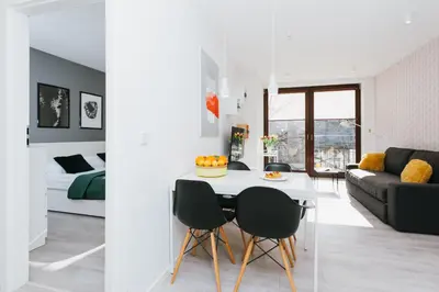 a kitchen and living room with a table and chairs at Horizon Apartments - Krowoderska in Kraków