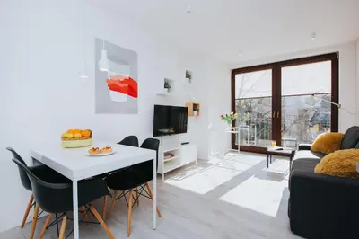 a living room with a white table and a couch at Horizon Apartments - Krowoderska in Kraków