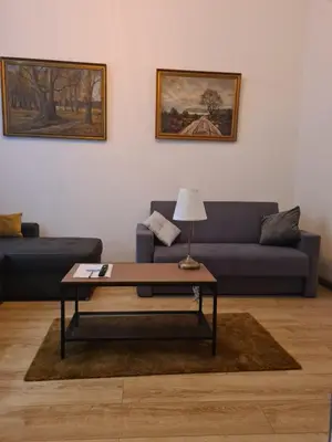 a living room with a blue couch and a coffee table at AMBER APARTAMENt 11 in Kraków