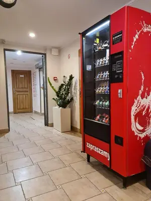 a red drink vending machine in a hallway at AMBER APARTAMENt 11 in Kraków