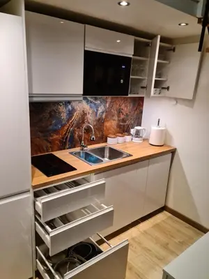 a kitchen with white cabinets and a sink at AMBER APARTAMENt 11 in Kraków