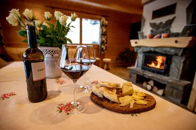 a bottle of wine and a glass of wine and cheese at Gorczańskie Siedlisko in Ochotnica Górna