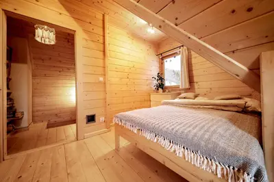 a bedroom with a bed in a log cabin at Gorczańskie Siedlisko in Ochotnica Górna
