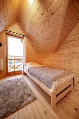 a bedroom with a bed in a log cabin at Gorczańskie Siedlisko in Ochotnica Górna
