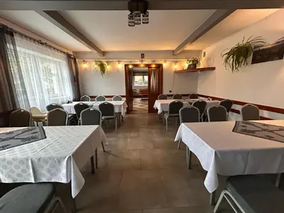 a room with tables and chairs with white tablecloths at Dom Wypoczynkowy U STASKA in Ochotnica Dolna