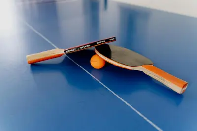 two tennis rackets and an orange ball on a table at Dom Wypoczynkowy U STASKA in Ochotnica Dolna