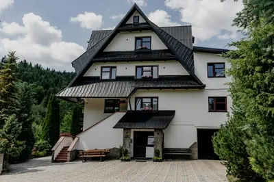 a large white house with a gambrel roof at Dom Wypoczynkowy U STASKA in Ochotnica Dolna