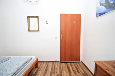 a bedroom with a bed and a wooden door at Hostel Cinnamon in Kraków