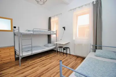 a room with two bunk beds and a desk at Hostel Cinnamon in Kraków