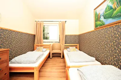 a room with two beds and a chair in it at Hostel Cinnamon in Kraków
