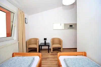 a room with two beds and a table and chairs at Hostel Cinnamon in Kraków