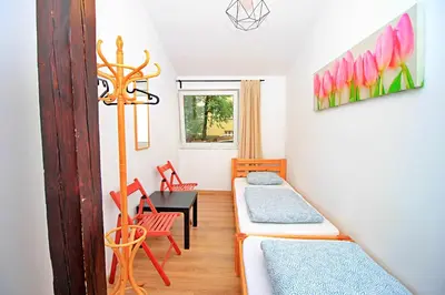 a room with two beds and a table and chairs at Hostel Cinnamon in Kraków