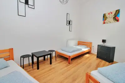 a bedroom with a bed and a table and chairs at Hostel Cinnamon in Kraków
