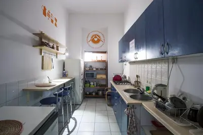 a kitchen with blue cabinets and sinks and a refrigerator at Hostel Cinnamon in Kraków