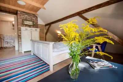 a bedroom with a bed and a vase with yellow flowers at Domek nad Galerią in Lanckorona