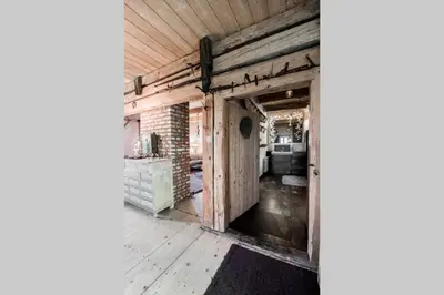 an open door in a barn conversion with a brick wall at Domek nad Galerią in Lanckorona