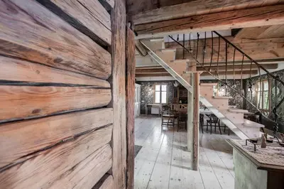 a barn door in a living room with a staircase at Domek nad Galerią in Lanckorona