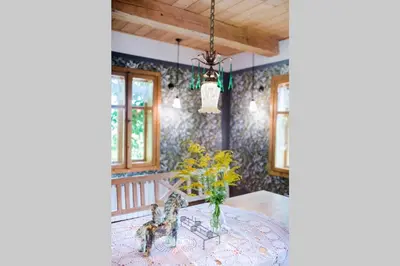 a dining room with a table with a vase of flowers at Domek nad Galerią in Lanckorona