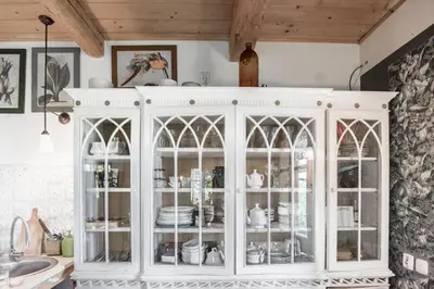 a white cabinet with glass doors in a kitchen at Domek nad Galerią in Lanckorona