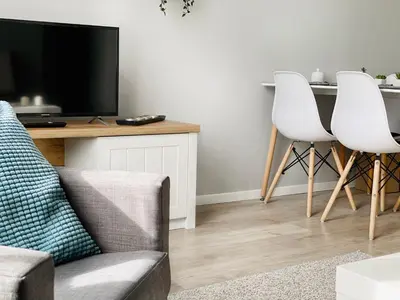 a living room with a couch and two white chairs at Cozy Apartment in the heart of Jewish District in Kraków